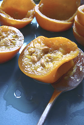 scooping the flesh out of poached Seville oranges